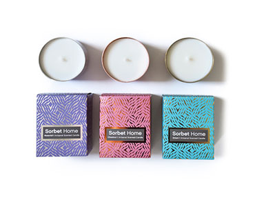 Three packages for candles in three different colors.