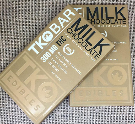 Beige box of milk chocolate from TKO BAR displaying benefits.