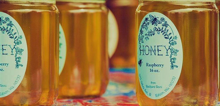 Close up on a jar of honey with a white label.