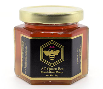 A jar of honey with a metal lid and a black label that reads "AZ Queen Bee".