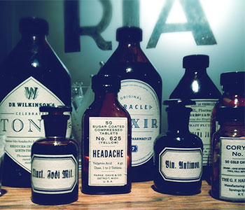 Antique looking glass bottles with white labels.
