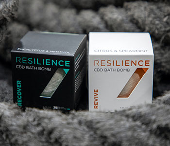 Two black and white boxes with CBD bath bombs that read "Resilience".