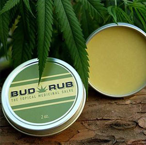 A small tin with a green label that reads "Bud Rub" under a marijuana leaf.