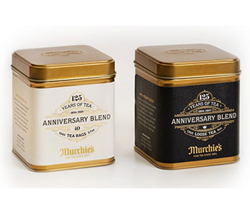Two metallic tins with different labels for various tea types.