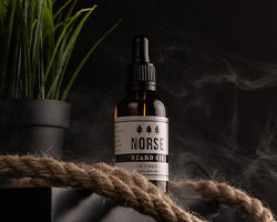 A black bottle of beard oil with a white label that reads "Norse".