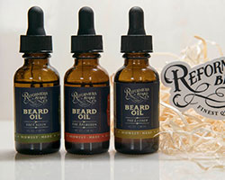 Three bottles of beard oil with a black label.