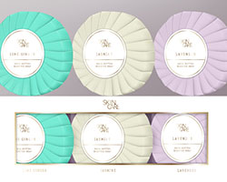 Three types of round soap wrapped in light blue, gray, and purple with a white label.