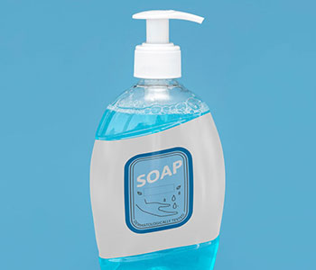 A container of liquid with a white pump lid and a gray label that reads "Soap".