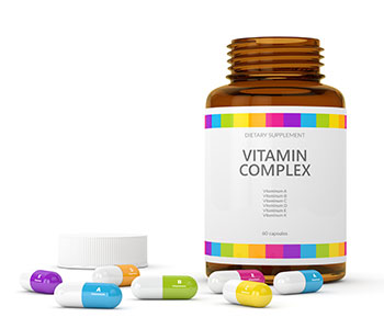 一個帶有白色標籤的容器，上面寫著“維生素複合物”和地上的五顏六色的藥丸。